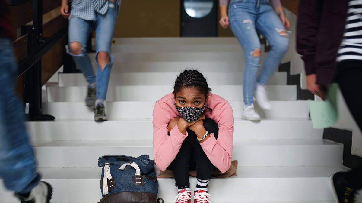 Teenage/young adult woman on sitting alone on staircase