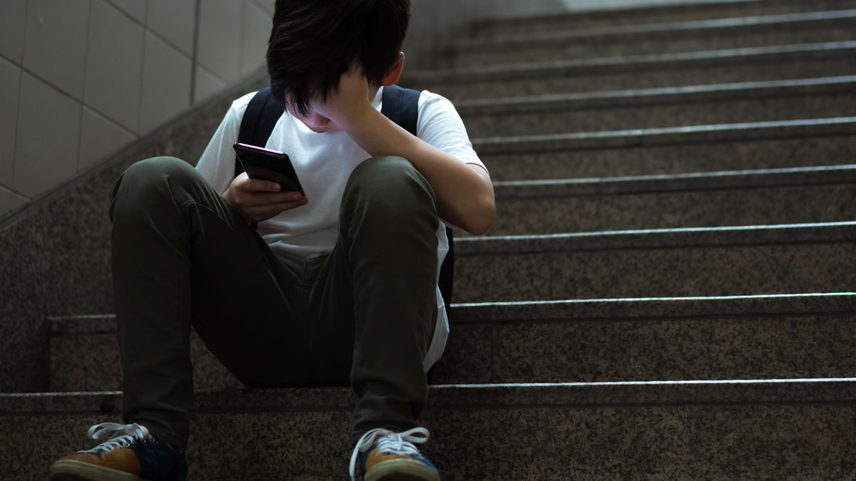 Young boy on staircase with head down