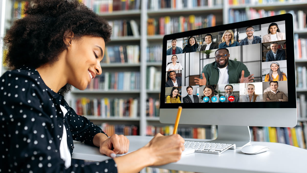 Woman in front of computer monitor with virtual meeting